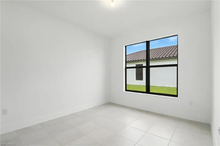 Empty room with baseboards and light tile patterned flooring