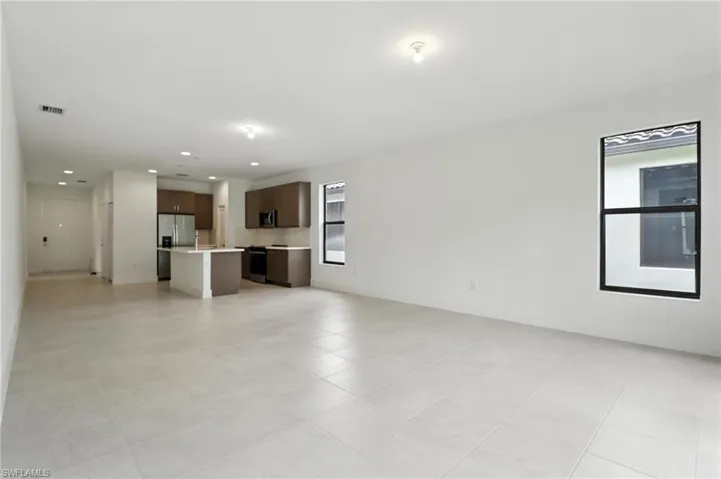 Unfurnished living room with recessed lighting and light tile patterned floors