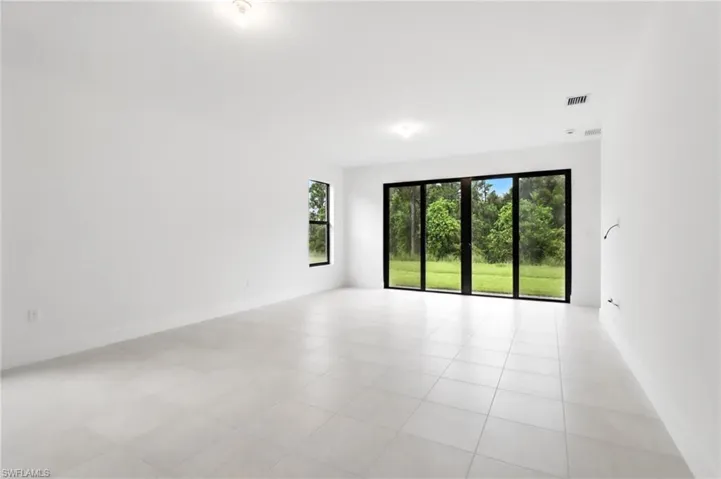Unfurnished room featuring light tile patterned flooring and baseboards