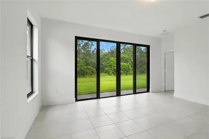 Empty room with light tile patterned floors and baseboards