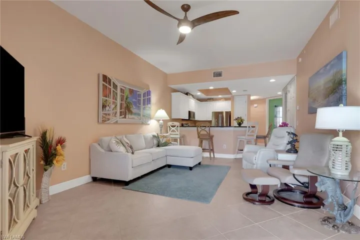 Living area with ceiling fan, recessed lighting, and light tile patterned floors