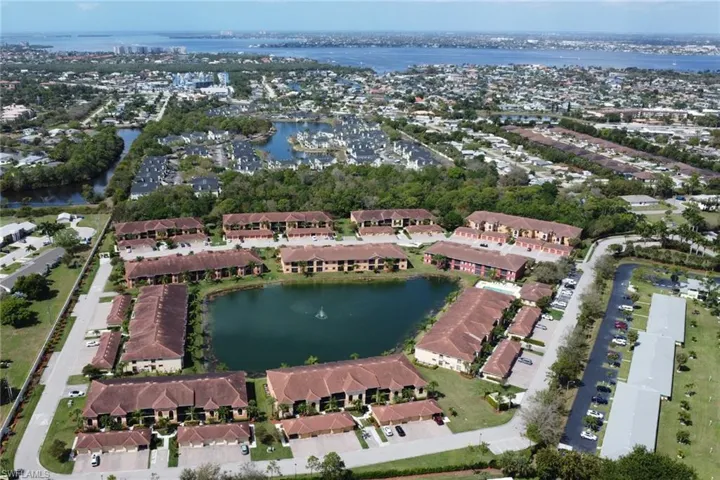 Aerial view of property's location featuring a nearby body of water and nearby suburban area