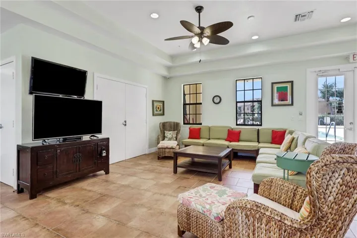 Living room with a ceiling fan, a raised ceiling, and recessed lighting