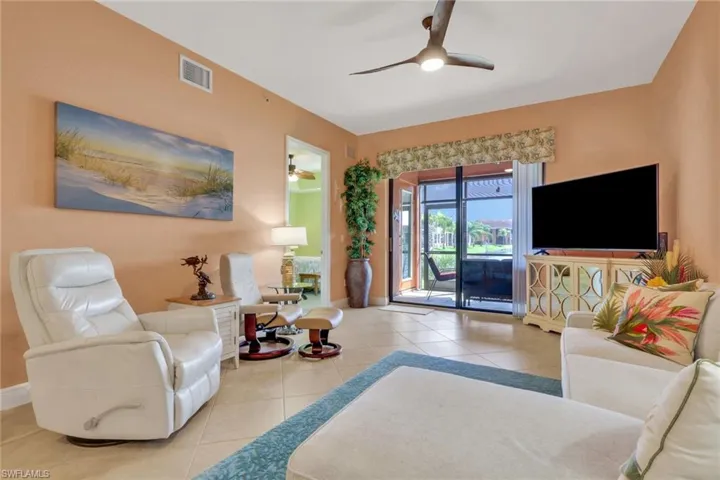 Living area featuring ceiling fan and light tile patterned flooring