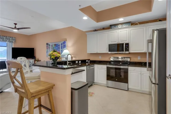 Kitchen featuring stainless steel appliances, a peninsula, white cabinetry, and recessed lighting