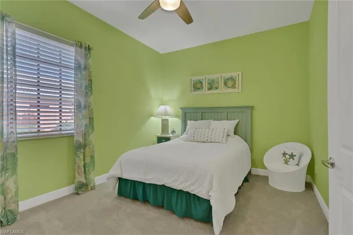 Carpeted bedroom with ceiling fan and baseboards