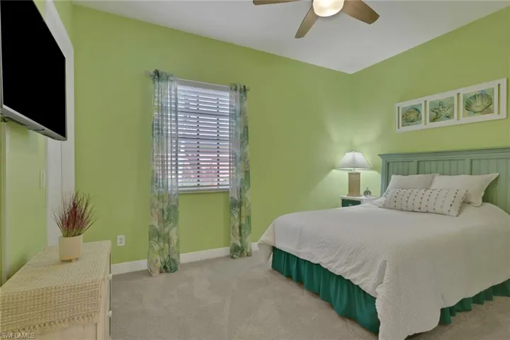 Bedroom featuring light colored carpet and a ceiling fan