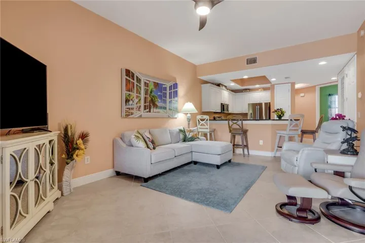 Living room with a ceiling fan, recessed lighting, and light tile patterned flooring