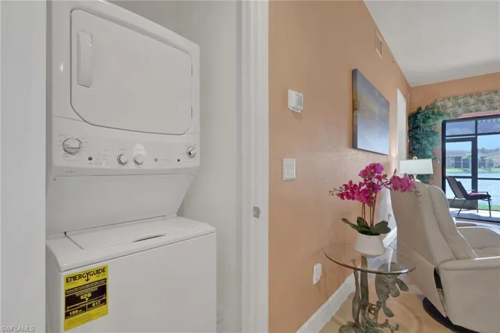 Laundry area featuring stacked washing machine and dryer and baseboards