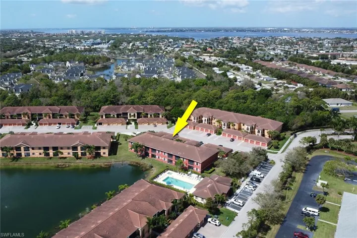 Aerial view of property and surrounding area with a nearby body of water