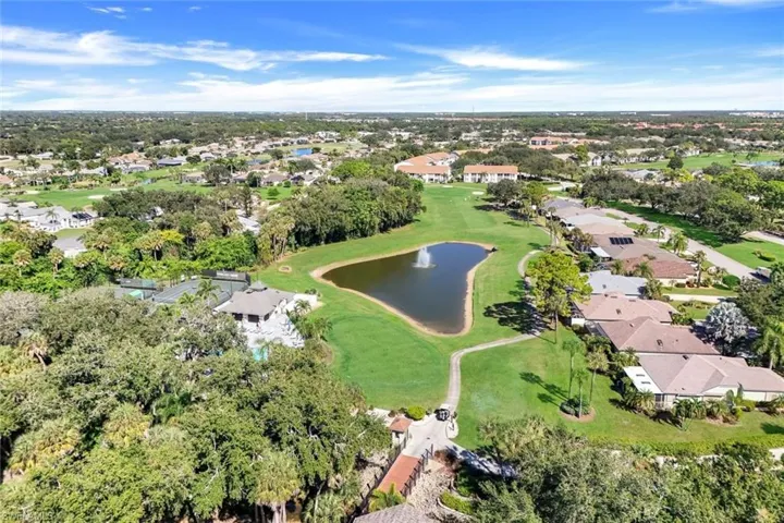 Aerial view of property and surrounding area featuring a large body of water, nearby suburban area, and a golf club