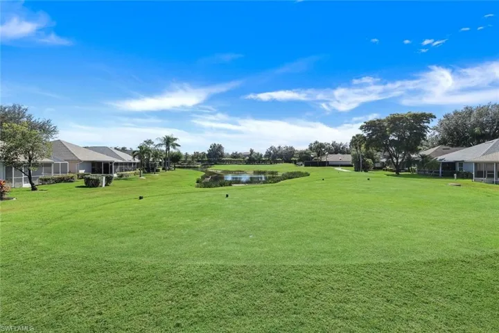View of green lawn featuring a water view and a sunroom