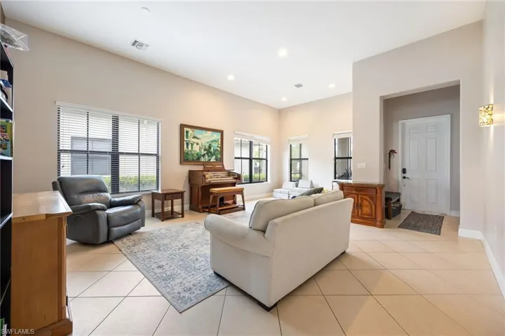Living room with light tile patterned floors and recessed lighting