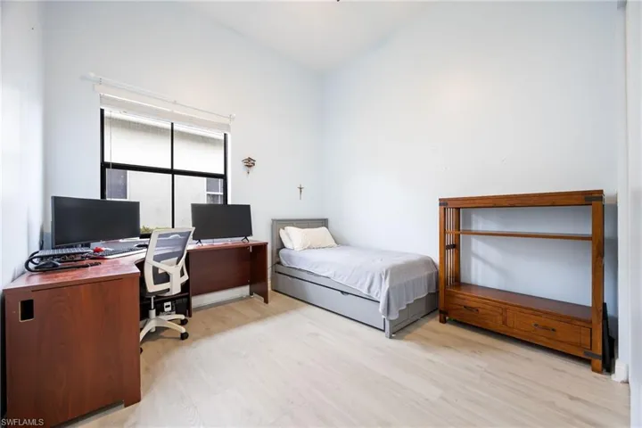 Bedroom with an office area and light wood-type flooring