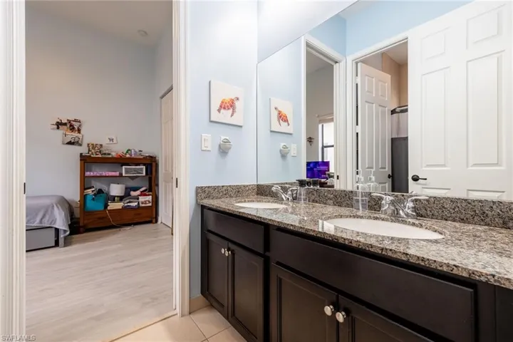 Ensuite bathroom featuring double vanity and light wood-style floors