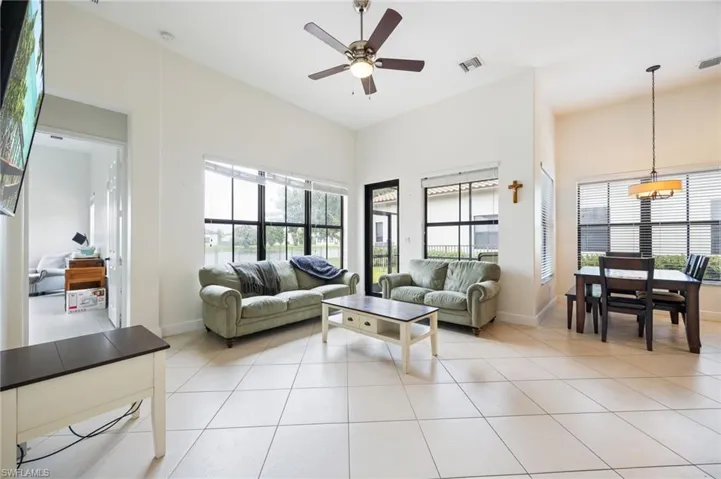 Living room with ceiling fan and light tile patterned floors