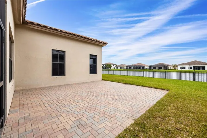 Fenced backyard with a patio area, a residential view, and a water view