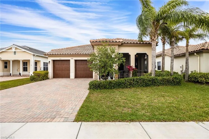 Mediterranean / spanish-style house featuring stucco siding, a front yard, an attached garage, and decorative driveway
