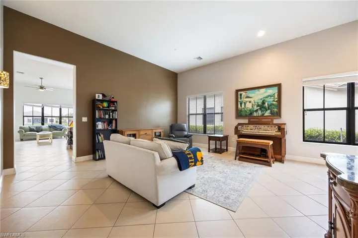Living area with a ceiling fan and light tile patterned floors