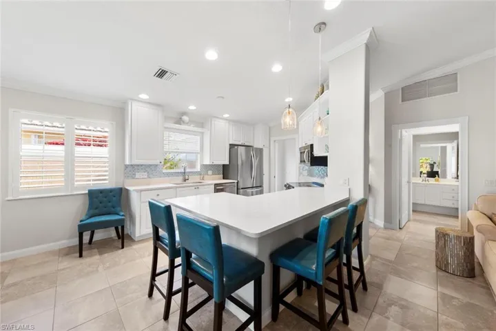 Kitchen featuring crown molding, visible vents, appliances with stainless steel finishes, and decorative backsplash