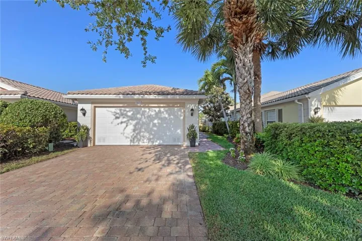 Ranch-style home with stucco siding, a tile roof, a garage, and decorative driveway