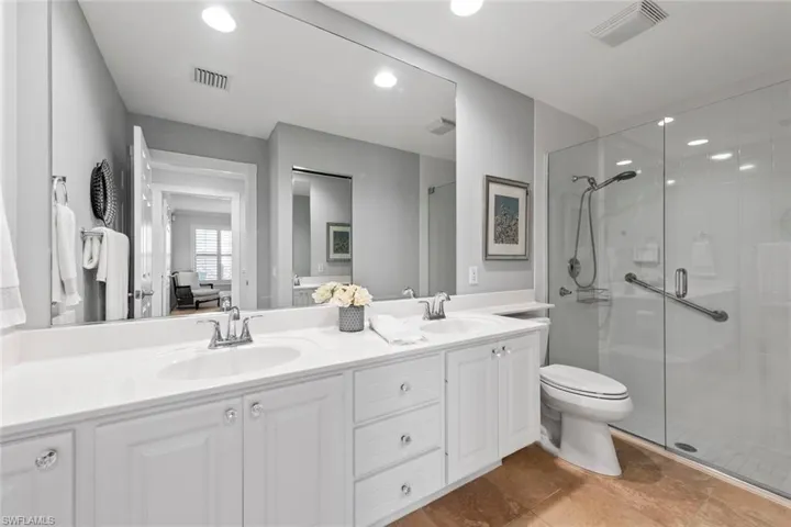 Bathroom with visible vents, a sink, and a shower stall