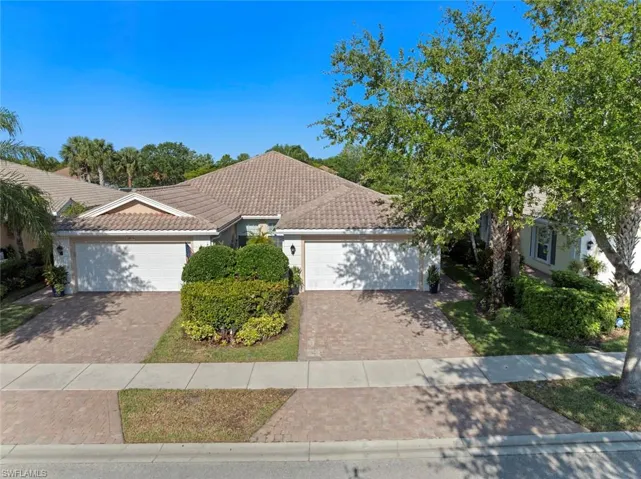 Ranch-style home with stucco siding, a tile roof, decorative driveway, and a garage
