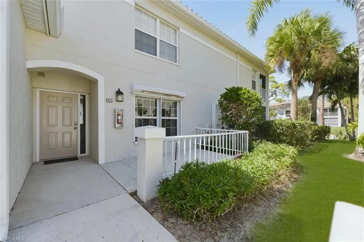 Doorway to property featuring stucco siding and a yard