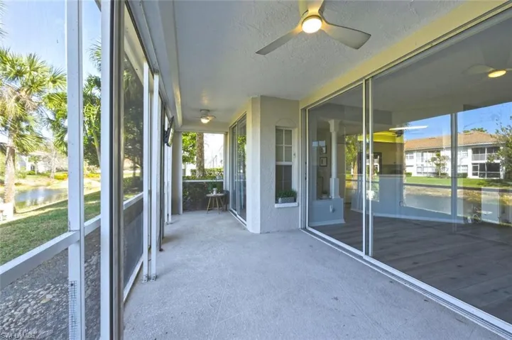 Unfurnished sunroom featuring a ceiling fan and a water view