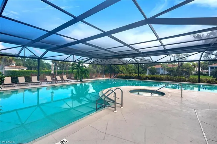 Community pool with an in-ground hot tub, a patio area, a sunroom, and glass enclosure