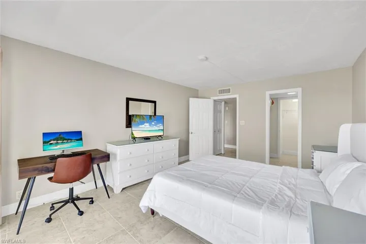 Bedroom featuring a spacious closet, a desk, and light tile patterned floors
