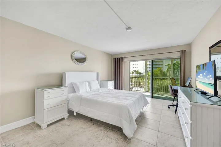 Bedroom with a desk, access to outside, and light tile patterned floors