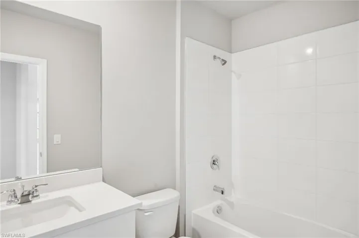 Bathroom featuring toilet, vanity, and tub / shower combination
