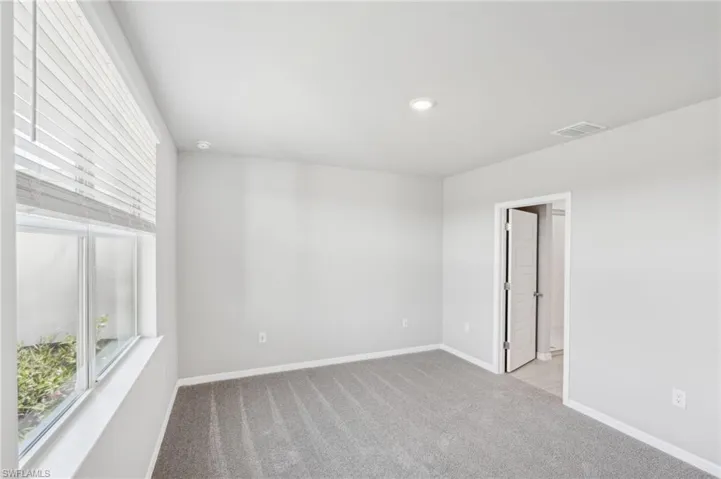 Unfurnished room featuring carpet floors, baseboards, recessed lighting, and a smoke detector