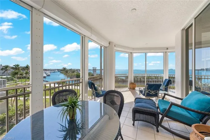Sunroom / solarium with a water view, a textured ceiling, and tile patterned flooring