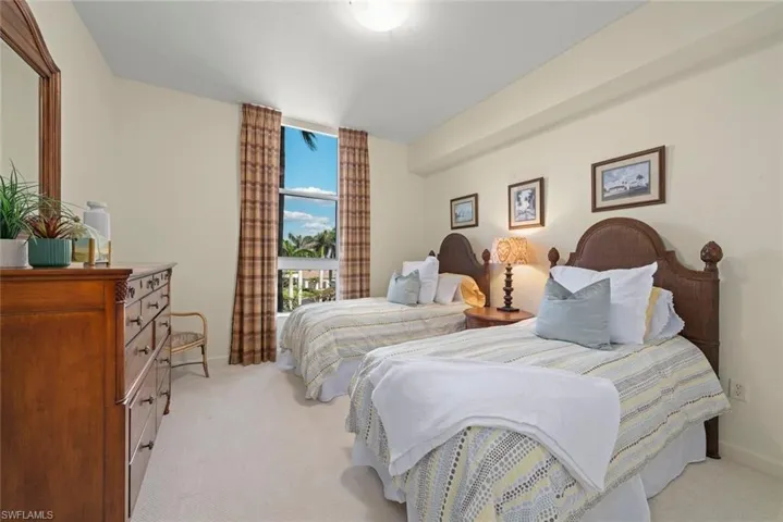 Bedroom featuring baseboards, floor to ceiling windows, and light colored carpet