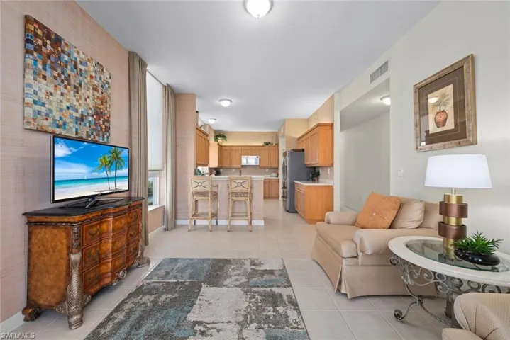Living area featuring baseboards, visible vents, and light tile patterned floors