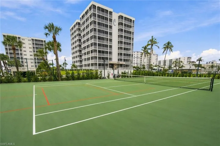 Outdoor tennis court with a green surface and white line markings