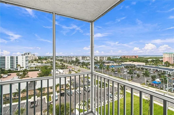 Screened balcony with a metal railing and expansive city and water scenery