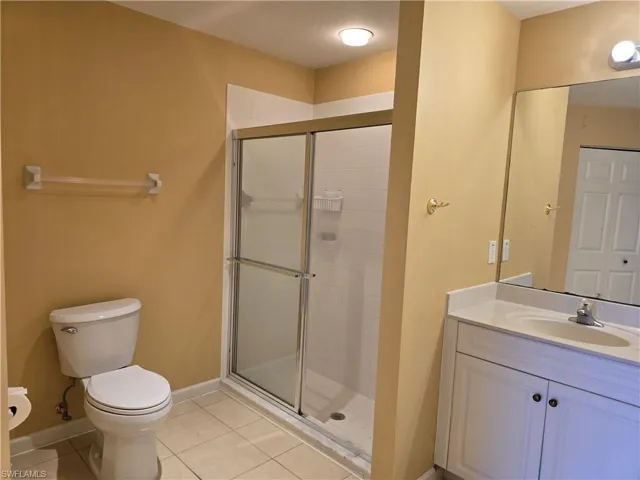 Bathroom with vanity, a shower stall, and light tile patterned flooring