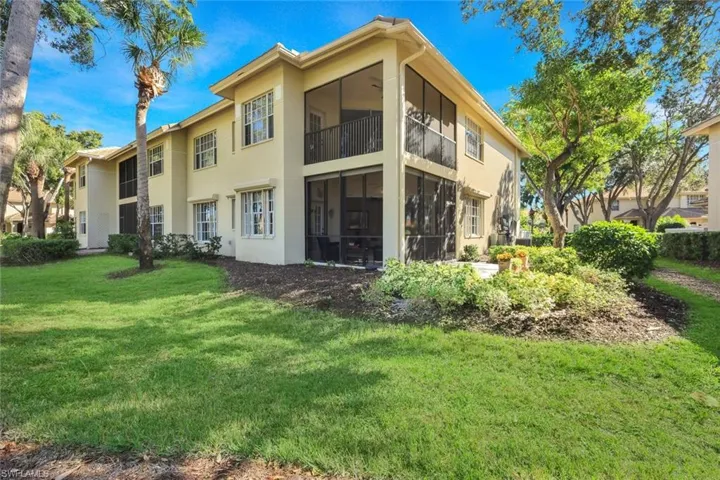 Back of home with a screened Lanai, a patio, stucco siding.