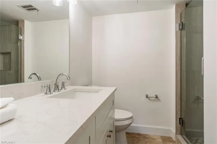 Full bathroom with a shower stall, vanity, and light tile patterned floors