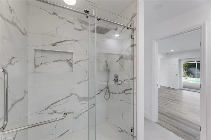 Primary bathroom featuring a tiled shower with a glass door.