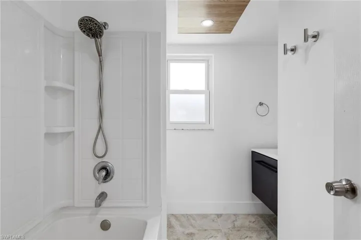 Bathroom with vanity and washtub / shower combination