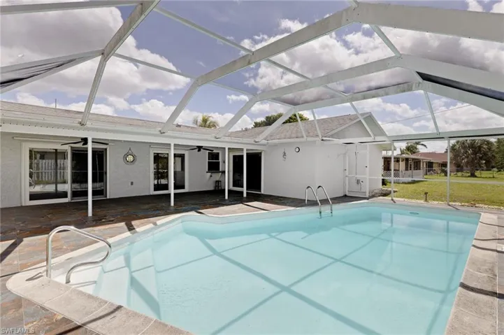 View of pool with a patio area, ceiling fans, and a lanai
