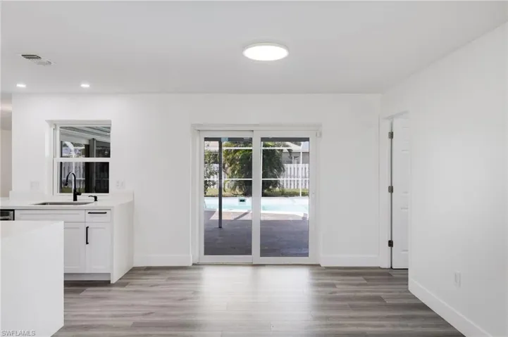 Dining area leading to pool through sliding door.