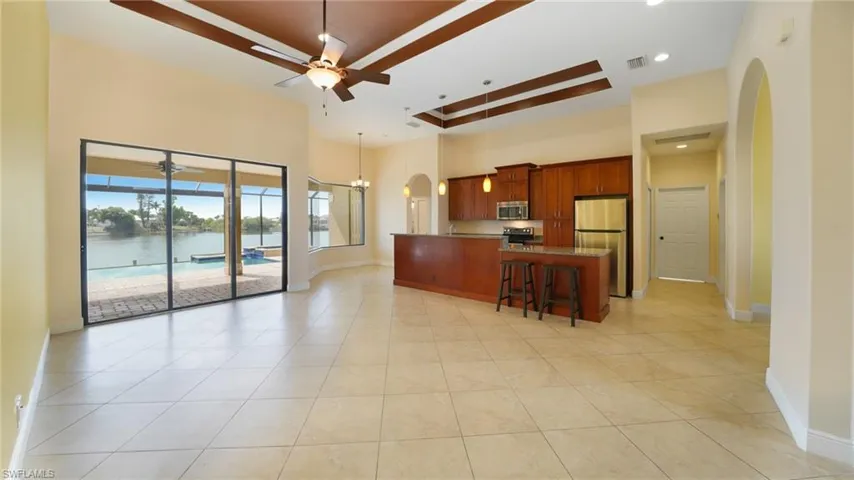 Triple slider to pool and lake beyond from living room with 12' ceilings that soar to 13'. Granite kitchen with breakfast bar island, stainless appliances, picture window breakfast nook, and beautiful arched doorways.