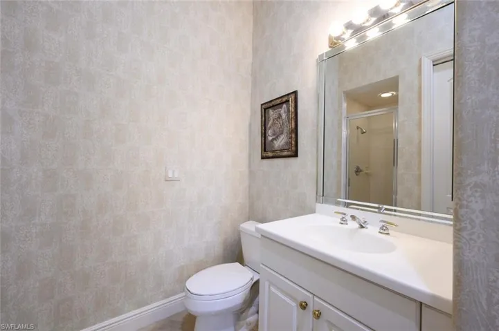 Bathroom across from 4th bedroom with single vanity and walk in tile shower.