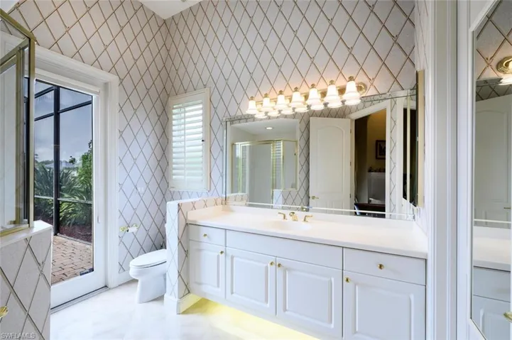 On of the Ensuite to the Primary Bedroom with Designer Lighting and Under Cabinet Lighting. There is a walk in closet on the right hand side.