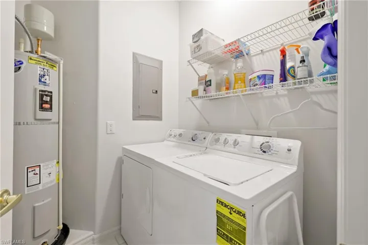 Laundry area featuring water heater, electric panel, and separate washer and dryer